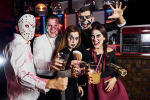posando para la cámara. Friends está en la fiesta temática de Halloween con maquillaje y disfraces aterradores. foto