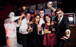 posando para la cámara. Friends está en la fiesta temática de Halloween con maquillaje y disfraces aterradores. foto