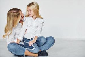 Mother with her daughter have fun together in the studio with white background photo