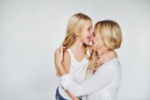 madre con su hija se divierten juntas en el estudio con fondo blanco foto