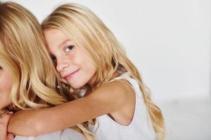 Mother with her daughter have fun together in the studio with white background photo