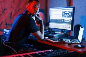 Guy have a job with project and mixing music indoors in the studio photo