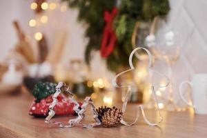 vasos y adornos navideños en la habitación. guirnaldas y luces brillantes foto