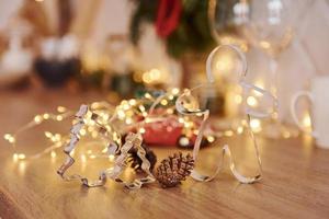 Glasses and x-mas decorations in the room. Bright garlands and lights photo