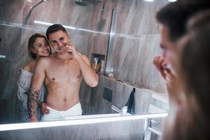 pareja joven juntos en el baño a la hora de la mañana foto