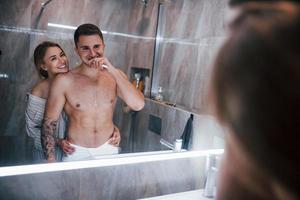 pareja joven juntos en el baño a la hora de la mañana foto