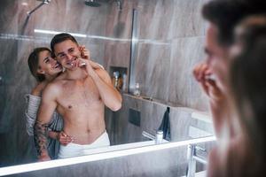 Young couple together in the bathroom at morning time photo