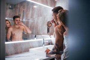 pareja joven juntos en el baño a la hora de la mañana foto