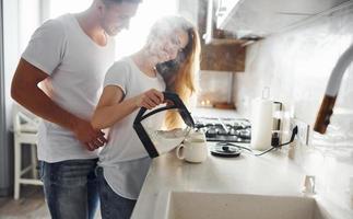 pareja joven en la mañana juntos de pie en la cocina moderna foto