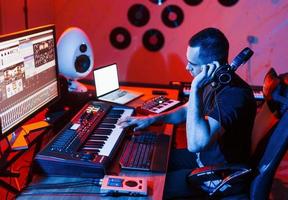 Young soung engineer working and mixing music indoors in the studio photo