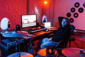 Sound engineer working and mixing music indoors in the studio near drum kit photo