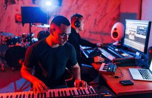Sound engineer have recording session with piano player indoors in the studio photo