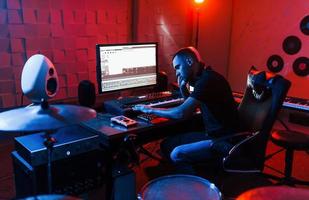 ingeniero de sonido trabajando y mezclando música en el interior del estudio cerca de la batería foto