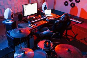 ingeniero de sonido trabajando y mezclando música en el interior del estudio cerca de la batería