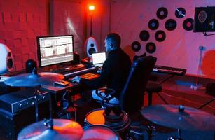 ingeniero de sonido trabajando y mezclando música en el interior del estudio cerca de la batería foto