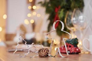 Glasses and x-mas decorations in the room. Bright garlands and lights photo