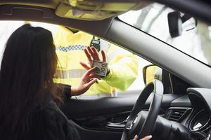 oficial de policía masculino con uniforme verde se niega a aceptar sobornos de una mujer en un vehículo foto