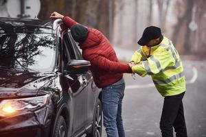 oficial de policía con uniforme verde atrapó el robo de automóviles en la carretera foto