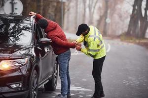 oficial de policía con uniforme verde atrapó el robo de automóviles en la carretera foto