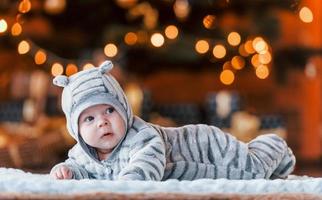 Cute little baby lying down in the christmas decorated room photo