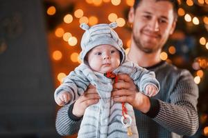 padre con su hijo juntos en una habitación decorada con navidad foto