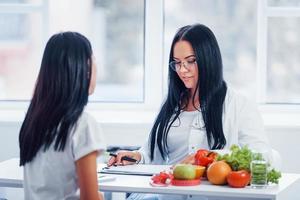 nutricionista femenina da consulta al paciente en el interior de la oficina foto