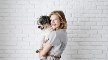Valentijnsdag dag. jong vrouw Holding haar hond in haar armen en zoenen video