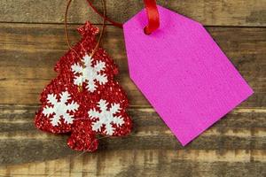 elementos decorativos de navidad junto a la tarjeta con cinta roja y espacio para escribir foto