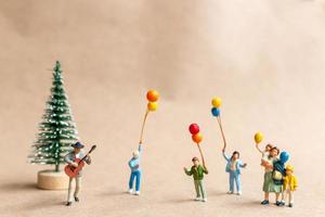 músicos en miniatura con una guitarra en el parque, conceptos de navidad y un feliz año nuevo foto
