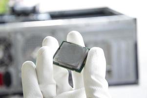 An image of a technician holding a CPU in his hand. photo