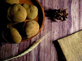 Pile of raw potatoes on dark wooden background. Preparation of potato soup or dish, perfect for advertising brochure background photo