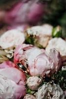 Bridal bouquet of pink peonies with wedding rings photo