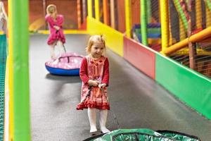 Children are dragged up the hill on an inflatable tube for riding . Two toddler girls on the playground photo