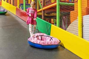 Children are dragged up the hill on an inflatable tube for riding . Toddler gir on the playground photo