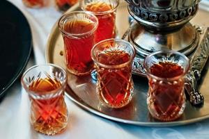 Tea in national Turkish glass glasses on a tray, next to the samovar photo