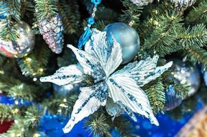 fondo de navidad de un árbol de navidad decorado con juguetes de navidad azul y una flor de navidad. vacaciones de invierno. Año Nuevo. foto