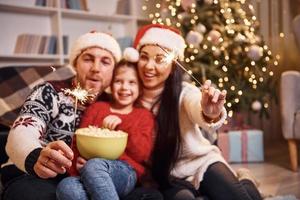 Happy family indoors in christmas hats have fun together and celebrating new year photo