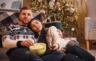 Young couple embracing each other indoors in christmas decorated room photo
