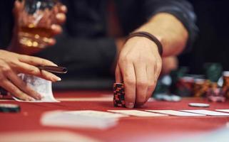 vista de cerca de las manos de los jóvenes elegantes que juegan al póquer en el casino foto