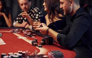 Group of elegant young people that playing poker in casino together photo