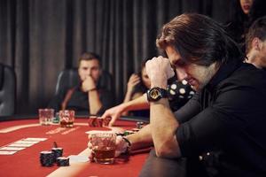 Group of elegant young people that playing poker in casino together photo