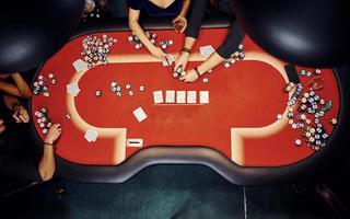 Top view of elegant young people that playing poker in casino photo