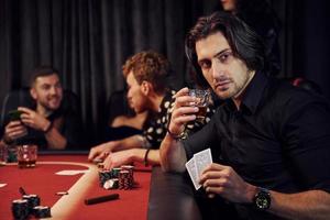 Group of elegant young people that playing poker in casino together photo