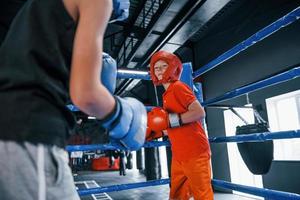 dos niños con equipo de protección tienen peleas y peleas en el ring de boxeo foto