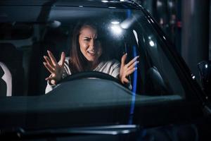 Young woman is inside of brand new modern automobile photo