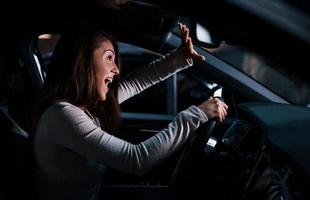 Side view of young woman that inside of brand new modern automobile photo