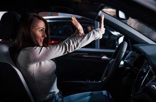 Side view of young woman that inside of brand new modern automobile photo