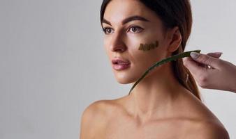 Naked woman is in the studio against white background with aloe vera photo