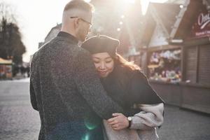 alegre pareja multirracial abrazándose al aire libre en la ciudad. chica asiática con su novio caucásico foto