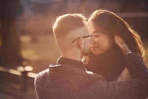 Beautiful sunlight. Happy multiracial couple together outdoors in the city photo